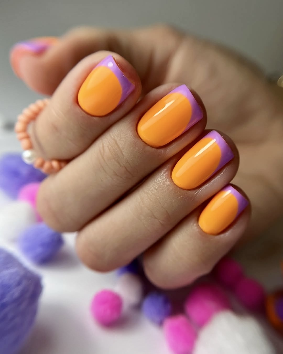 Orange nails with purple accents