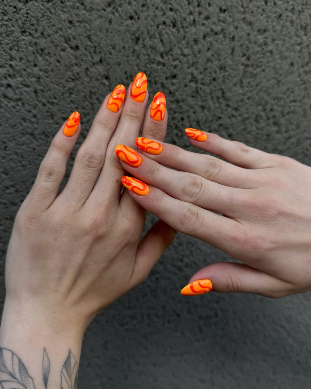 Neon orange nails with abstract waves