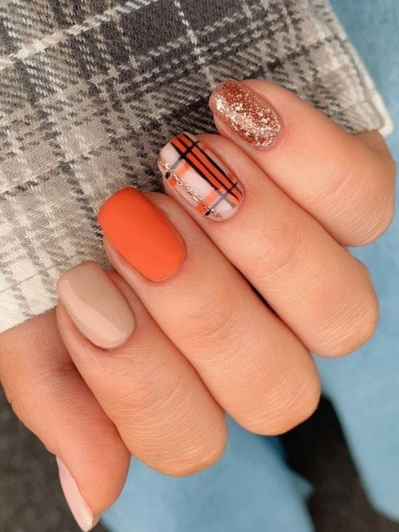 Matte orange nails with plaid and glitter
