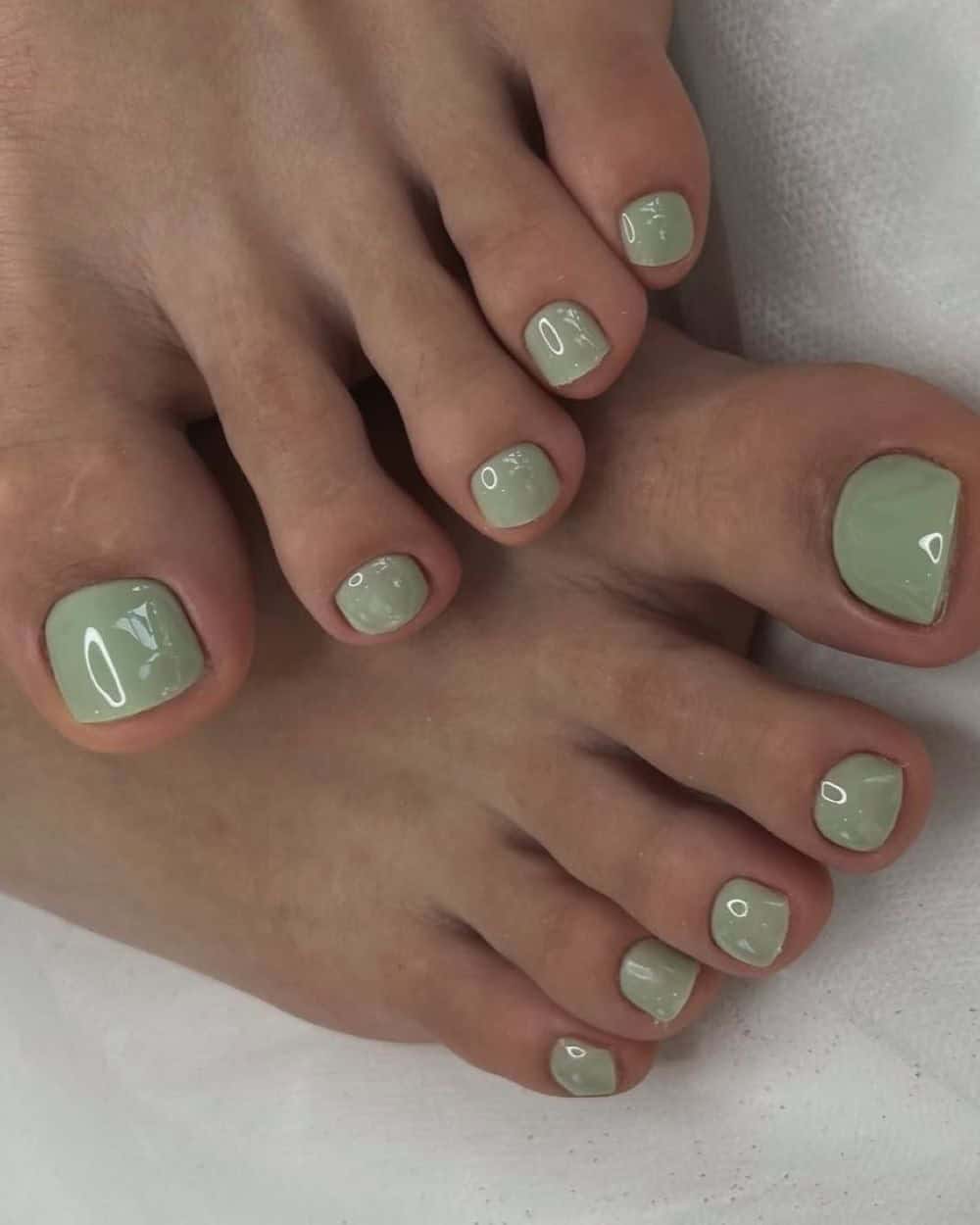 Sage green pedicure with soft glossy finish on square nails