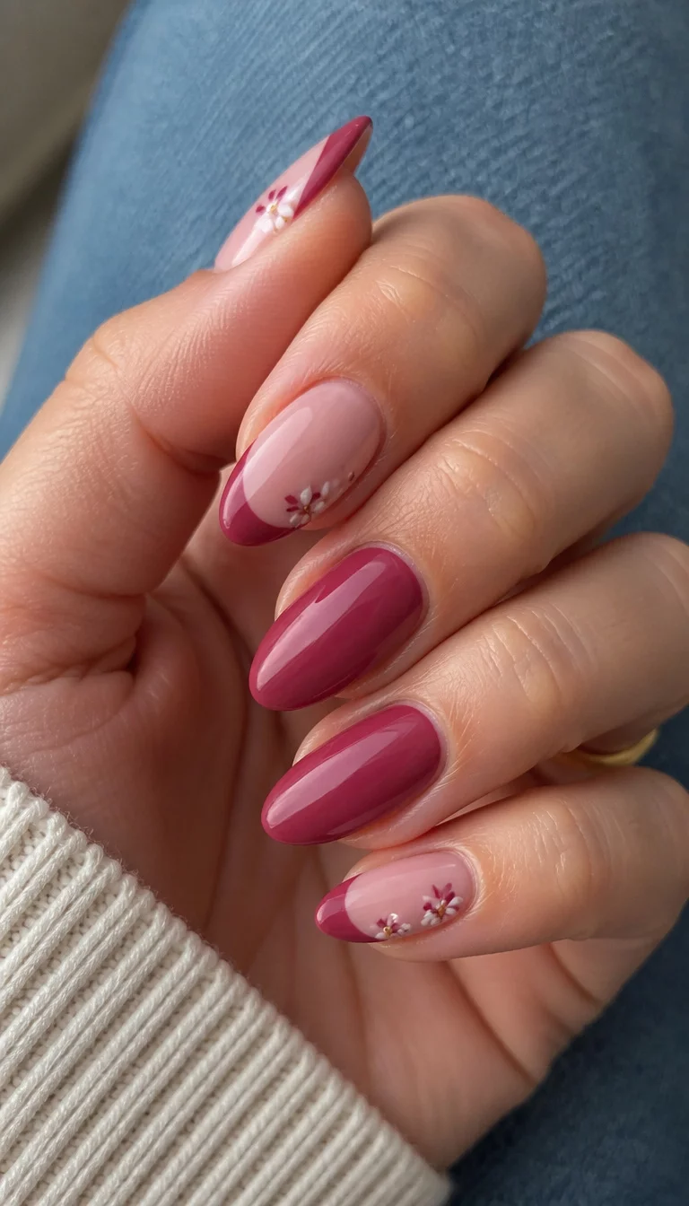 Burgundy French manicure with floral accents, bold and elegant.
