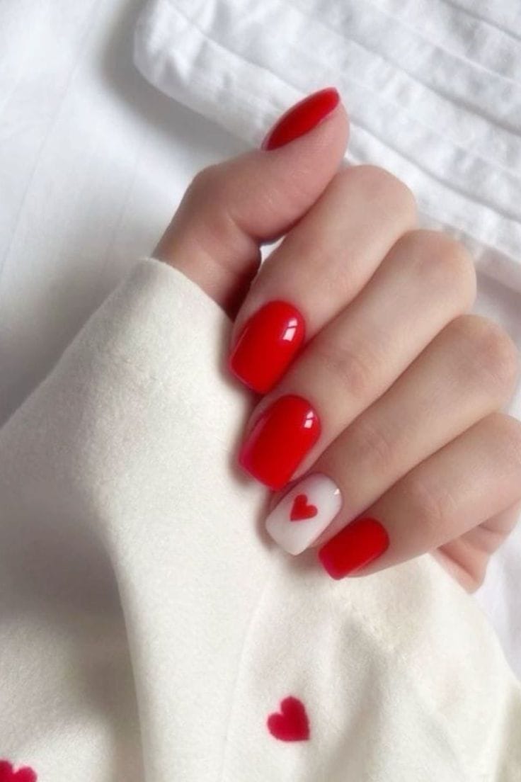 Bright red nails with heart accent