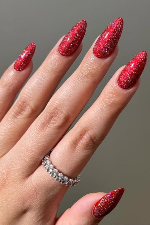Glittering red stiletto nails with sparkle