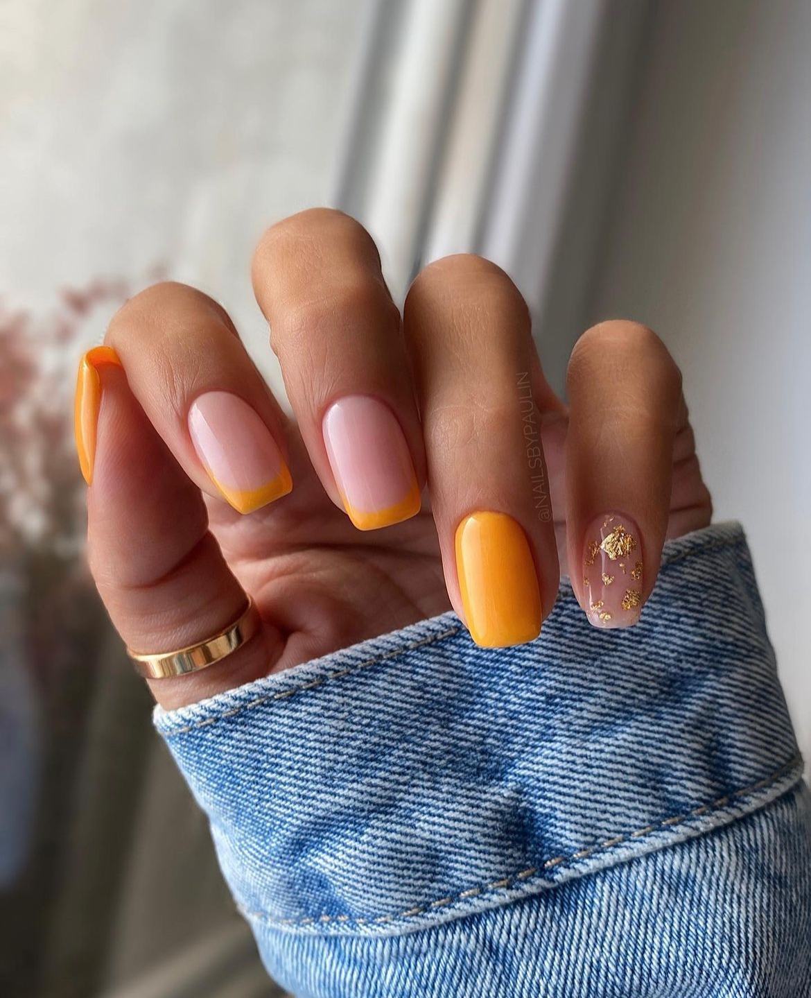 Yellow French tip nails with gold foil accent