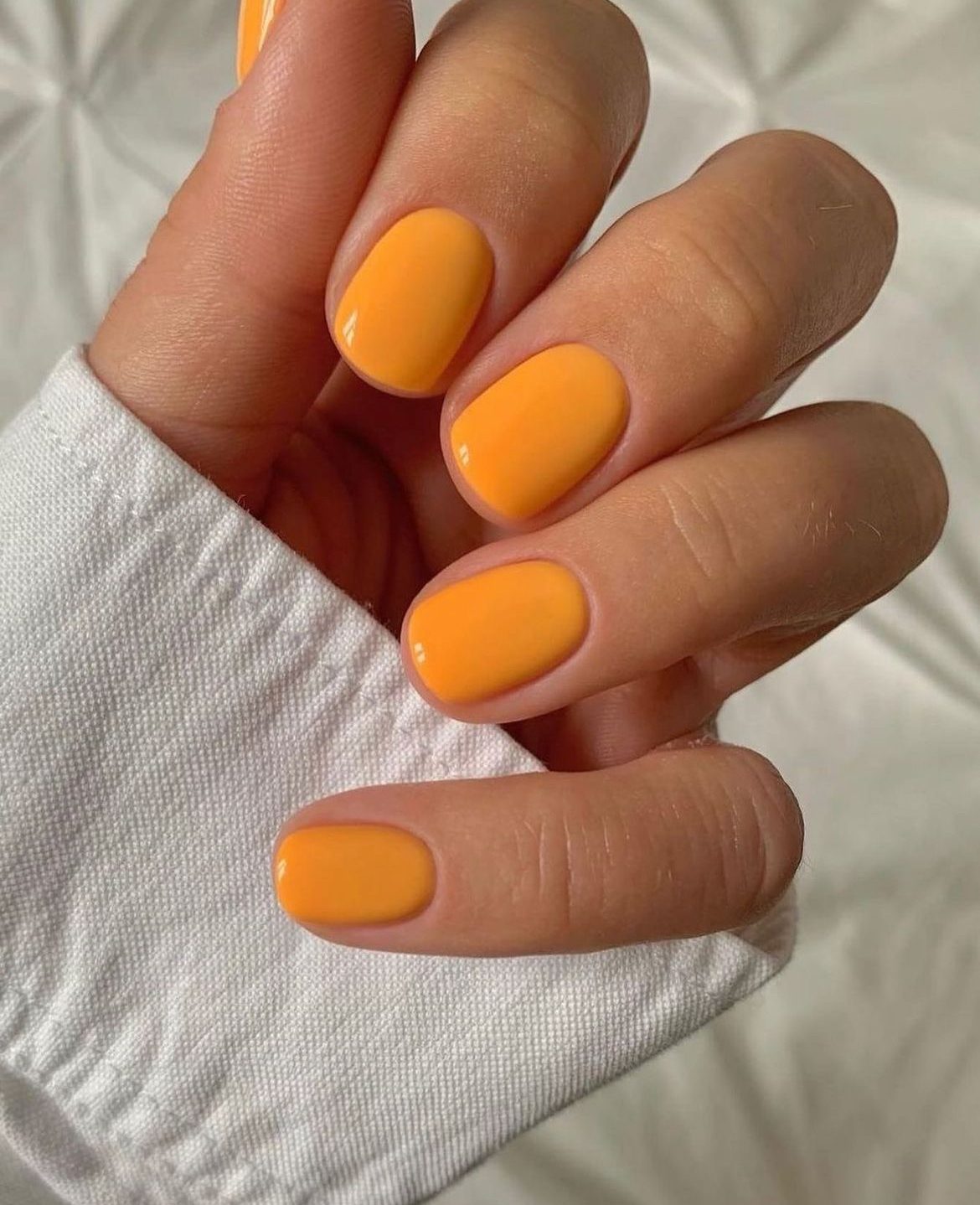 Orange short oval nails with glossy finish