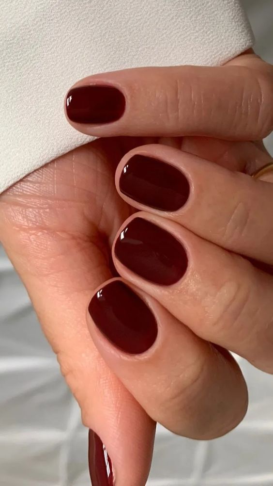 Short oval burgundy nails with glossy finish
