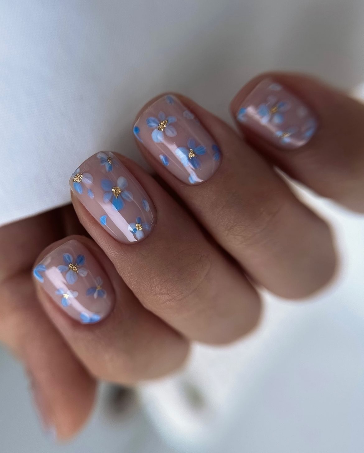 Short nude nails with blue flower designs