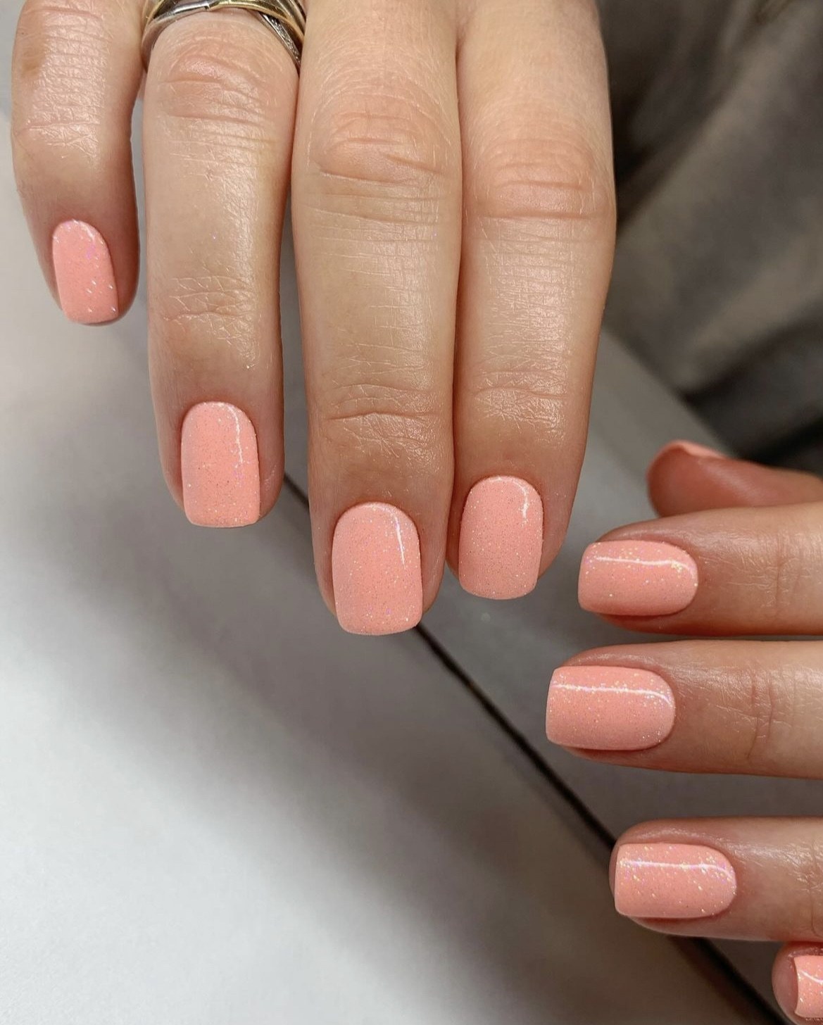 Peach shimmer nails, short and chic, ideal for Pinterest's spring and summer boards.