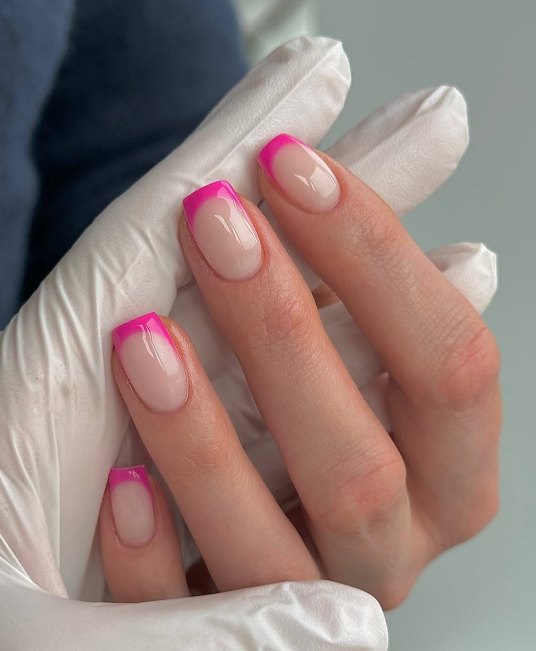 Neon pink French tips on short nails, playful and trendy.