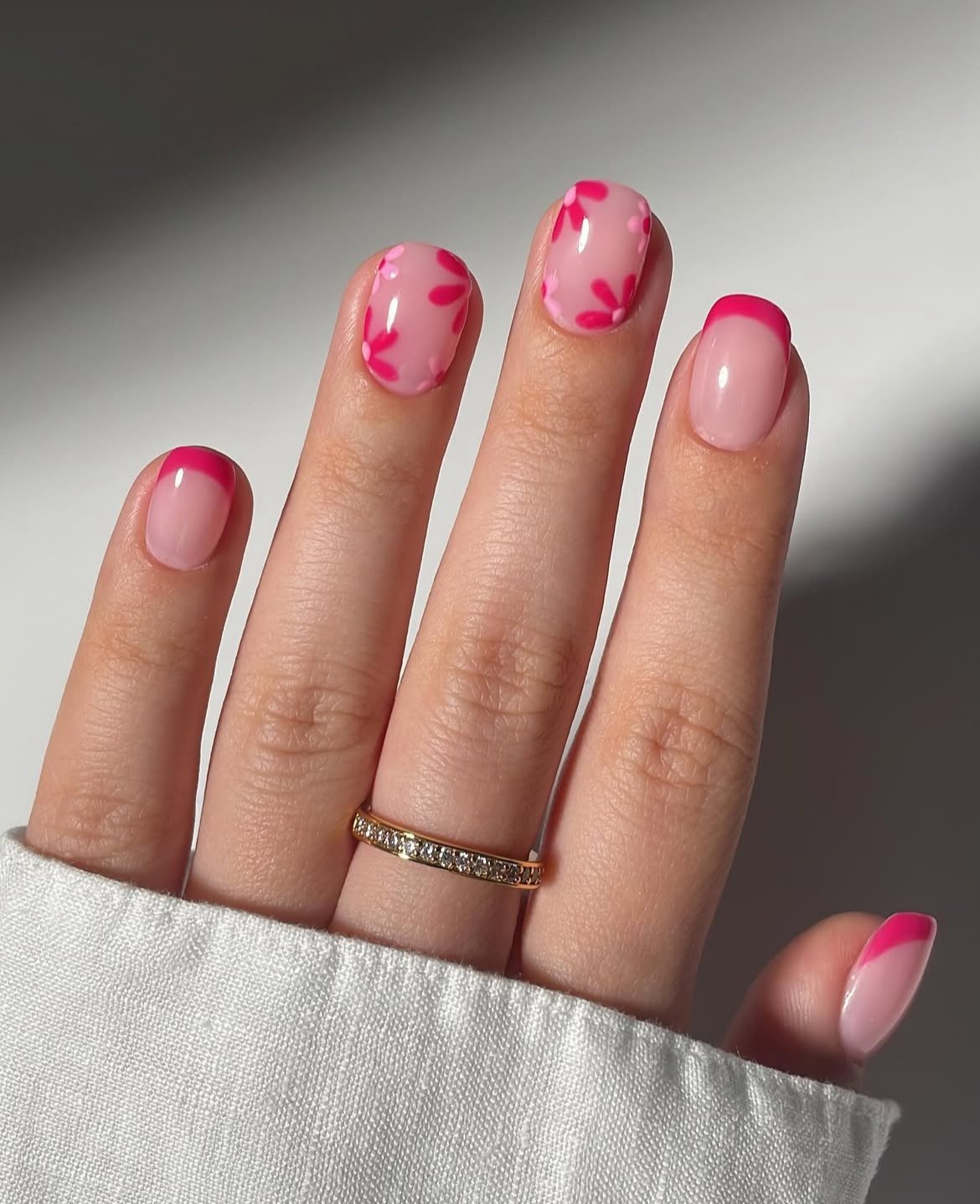 Pink French nails with floral design, playful and chic.