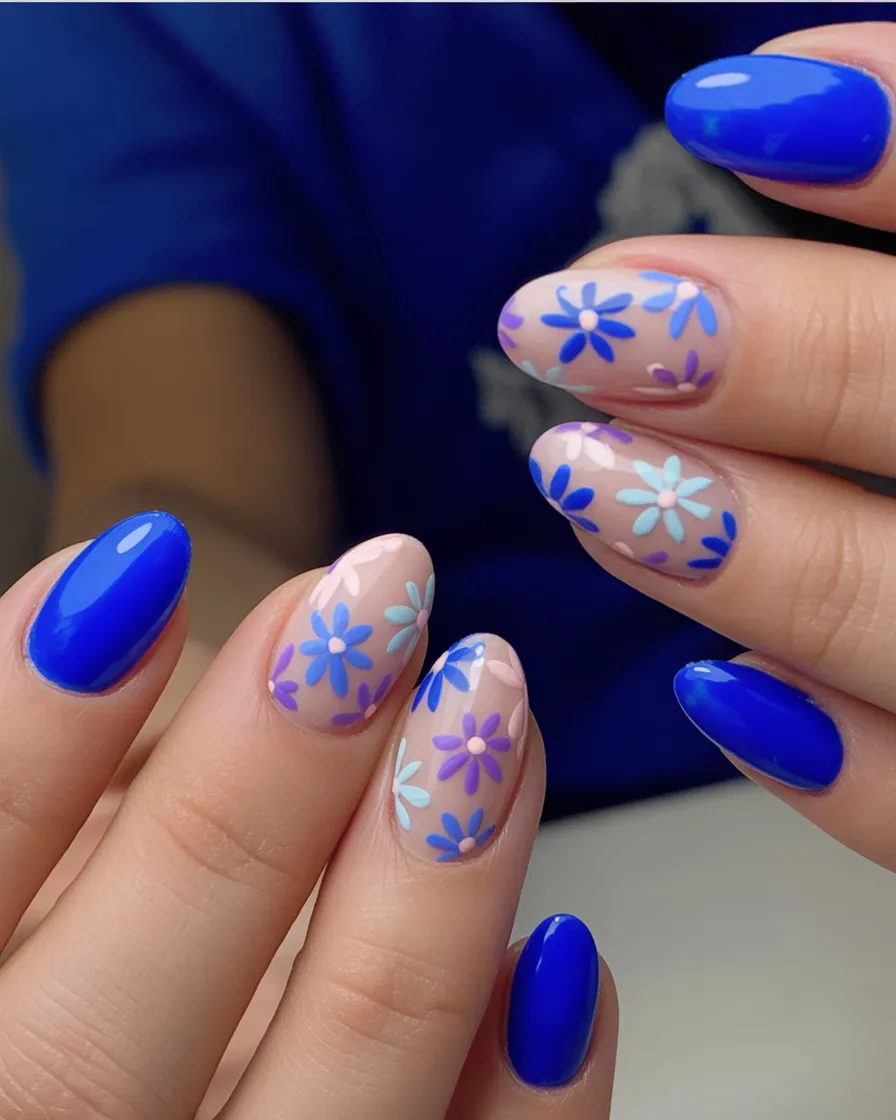 Blue nails with daisy designs, vibrant and fresh.