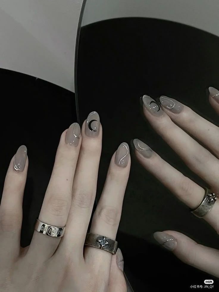 Dark nails with moon motifs, mystical and elegant.