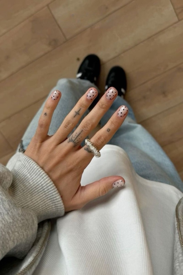 Short gel nails with black polka dots on nude base
