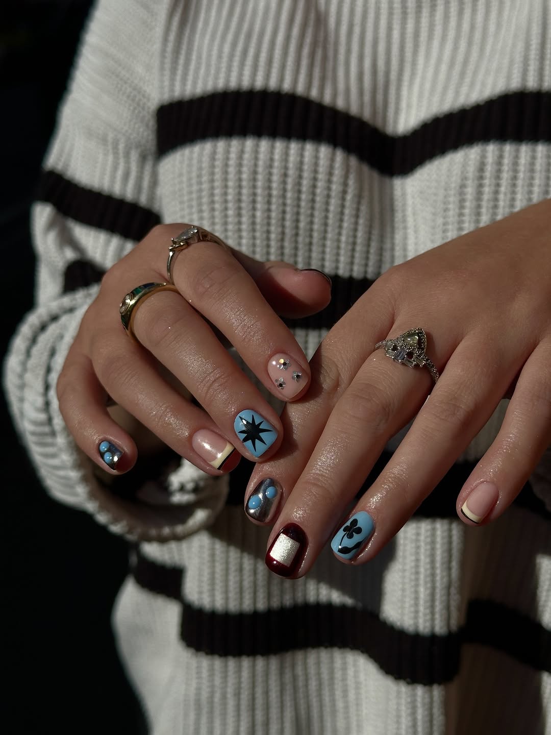 Short gel nails with eclectic art on a blue base