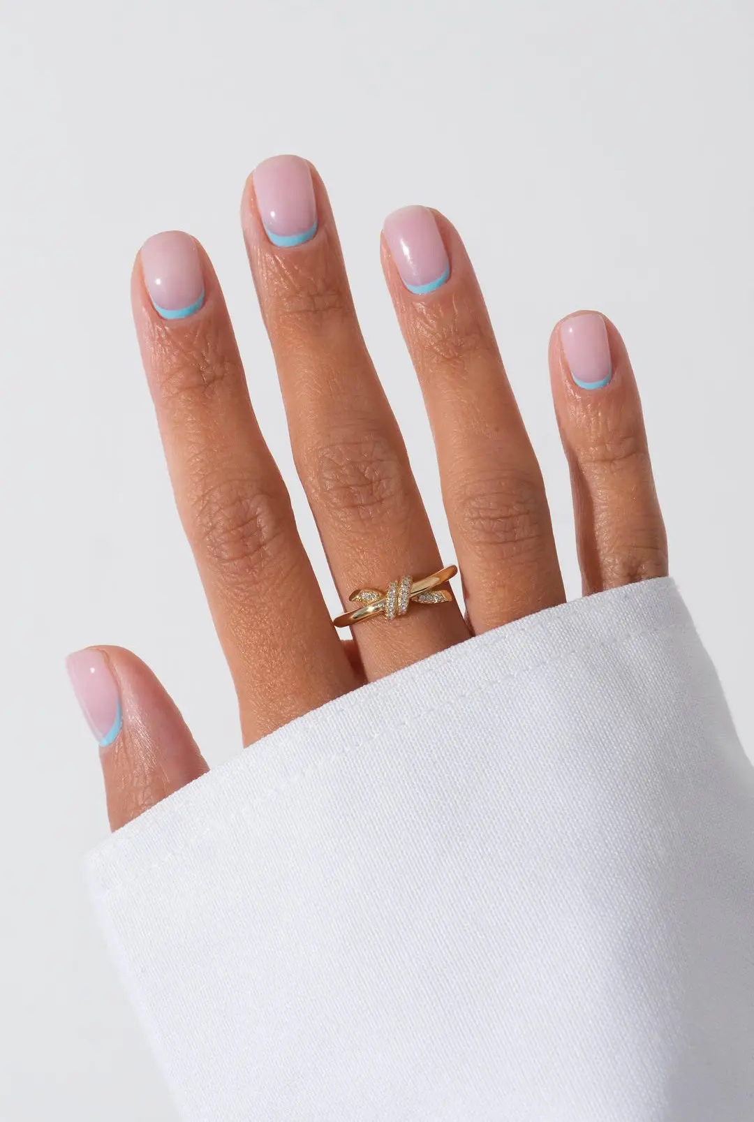 Short square nails with blue micro-French tips, modern nail aesthetic.