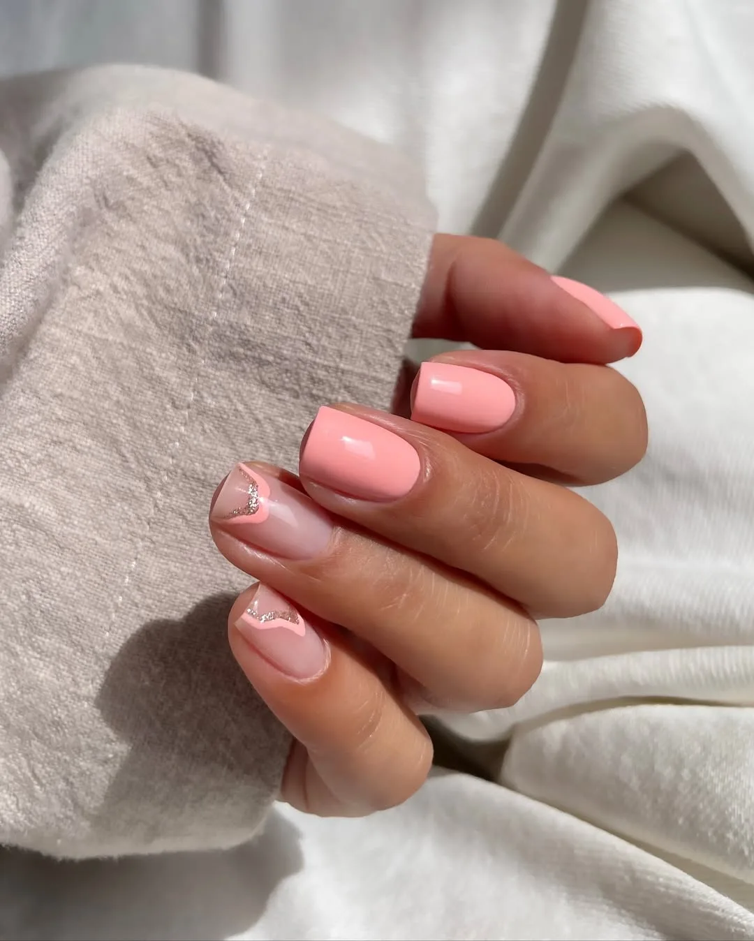 Short square nails in peach with delicate accents, chic and subtle.