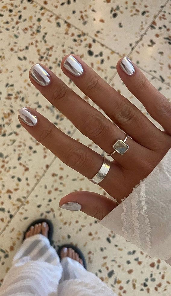 Short oval nails with sleek silver finish, minimalist nail art
