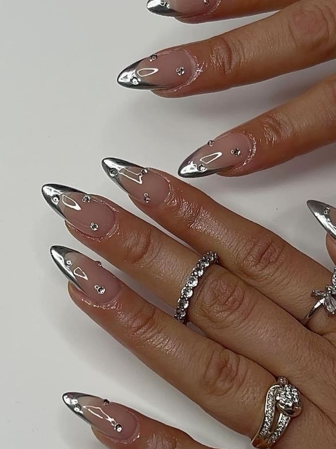 Stiletto nails with chrome and jewels, luxurious nail design