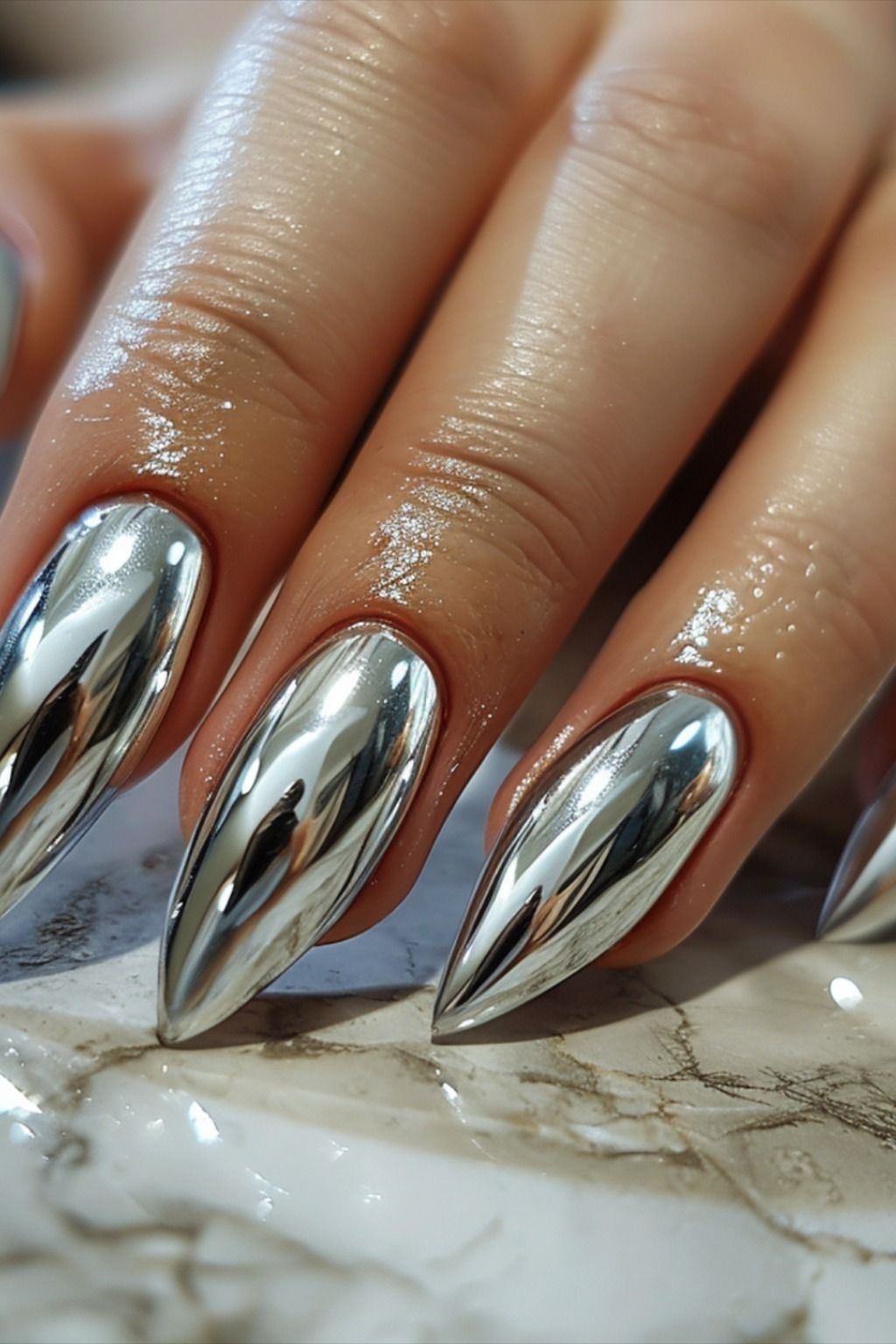 Long almond nails with reflective chrome finish, sophisticated look