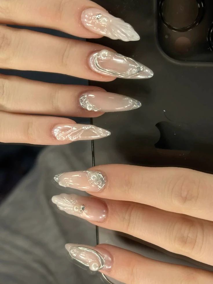 Stiletto nails with silver 3D designs, artistic nail art