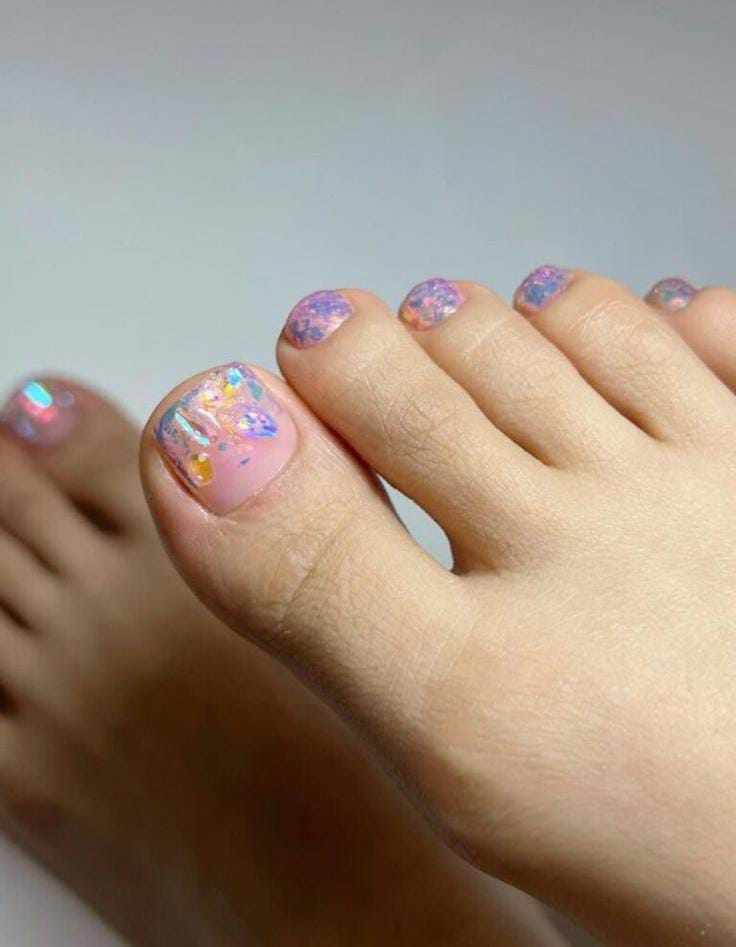Pastel confetti glitter toe nail design with a playful vibe