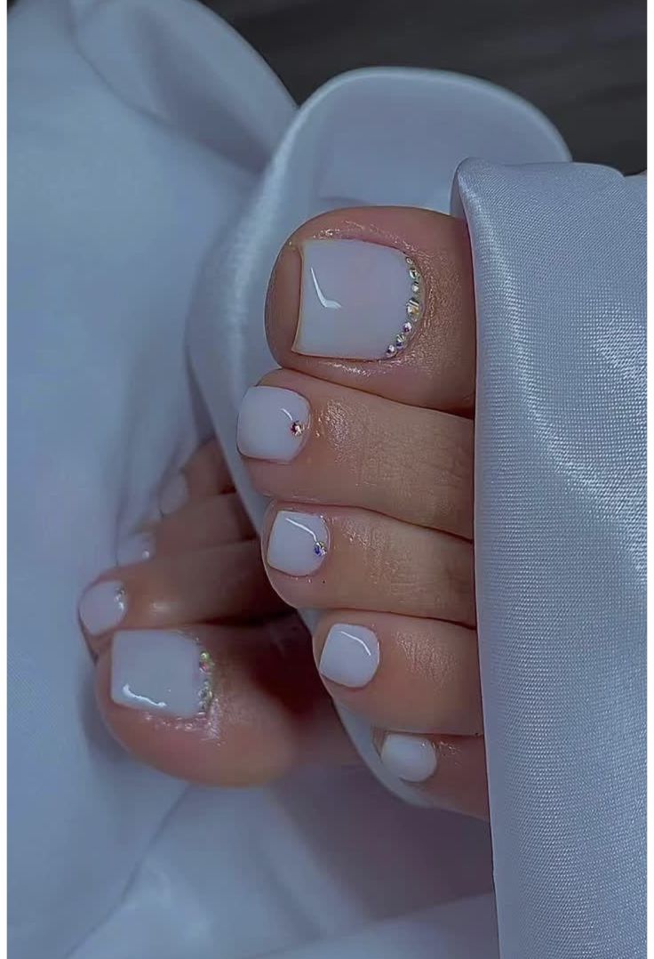 White pearl toe nail design with delicate rhinestone accents