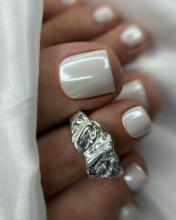Pearl white toe nails with a glossy finish