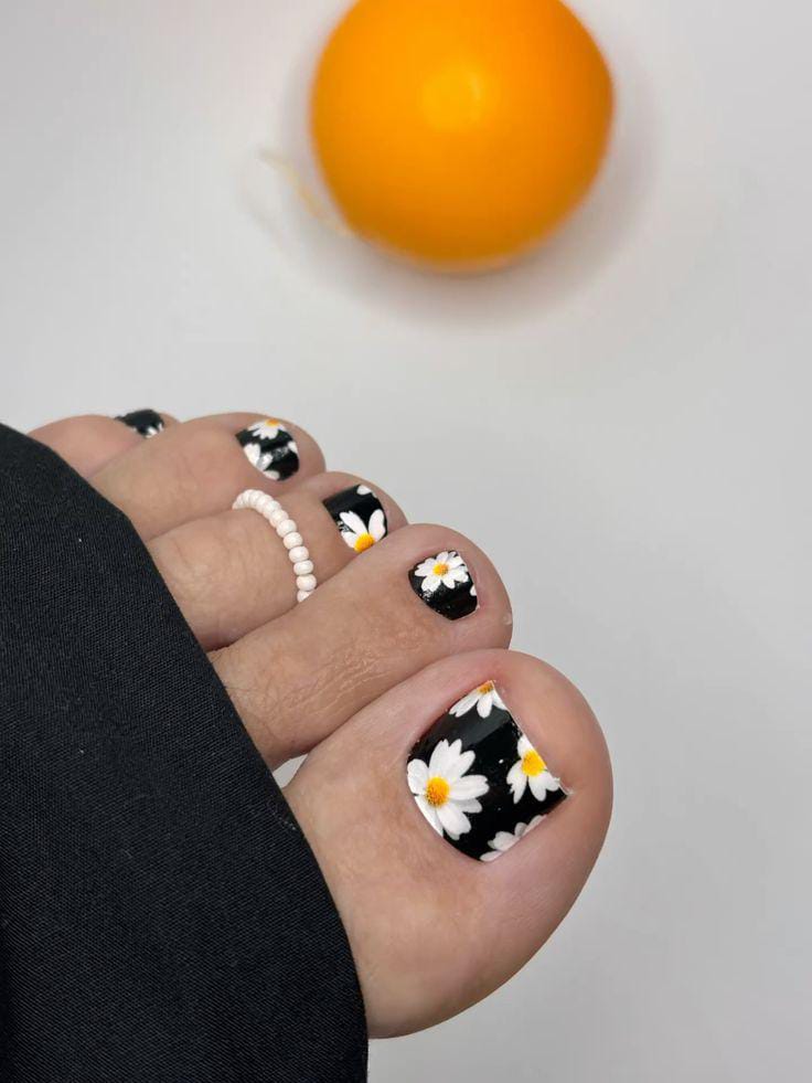 Black toe nails with white daisy patterns