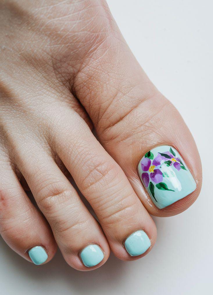 Mint green toe nails with purple floral art