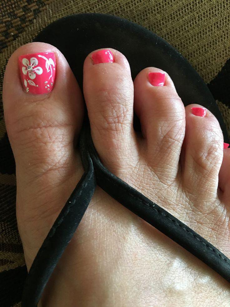 Bright pink toe nails with white floral accents