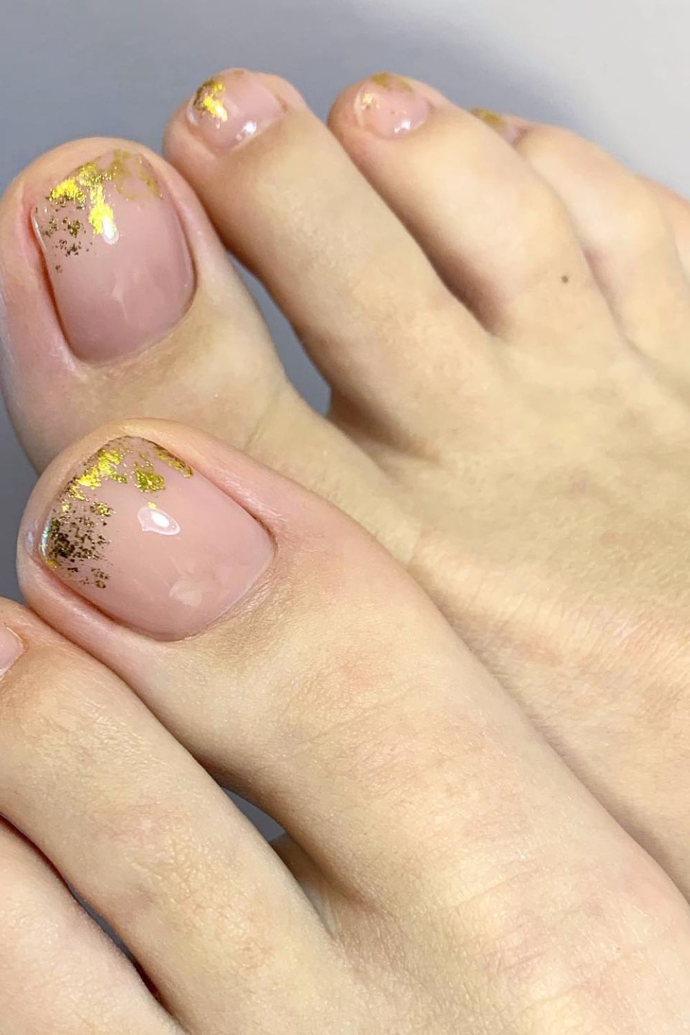 Nude toe nails with gold leaf accents