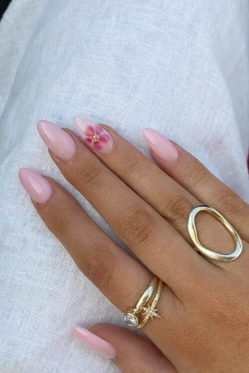 Elegant pink nails with floral accent.