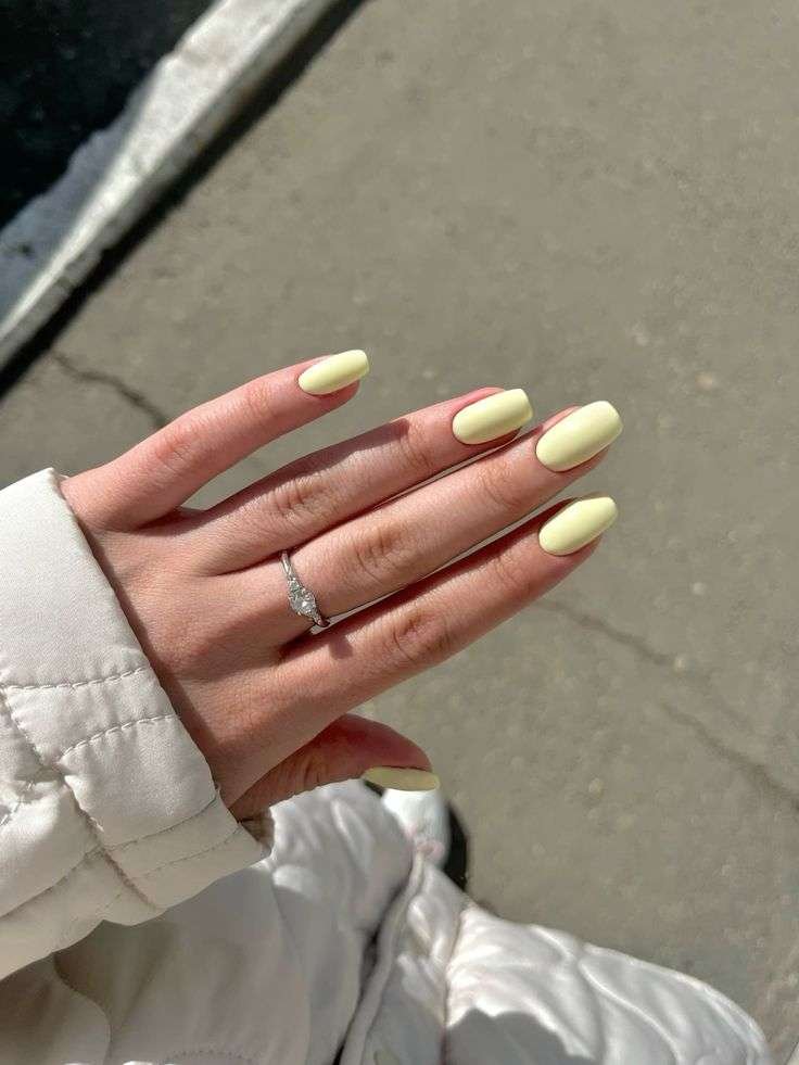 Chic lemon yellow nails in almond shape.