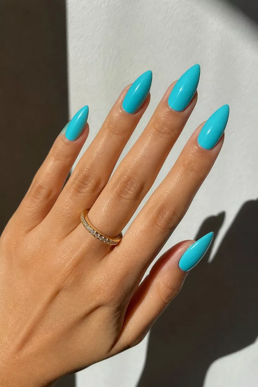 Vibrant turquoise stiletto nails for bold look.