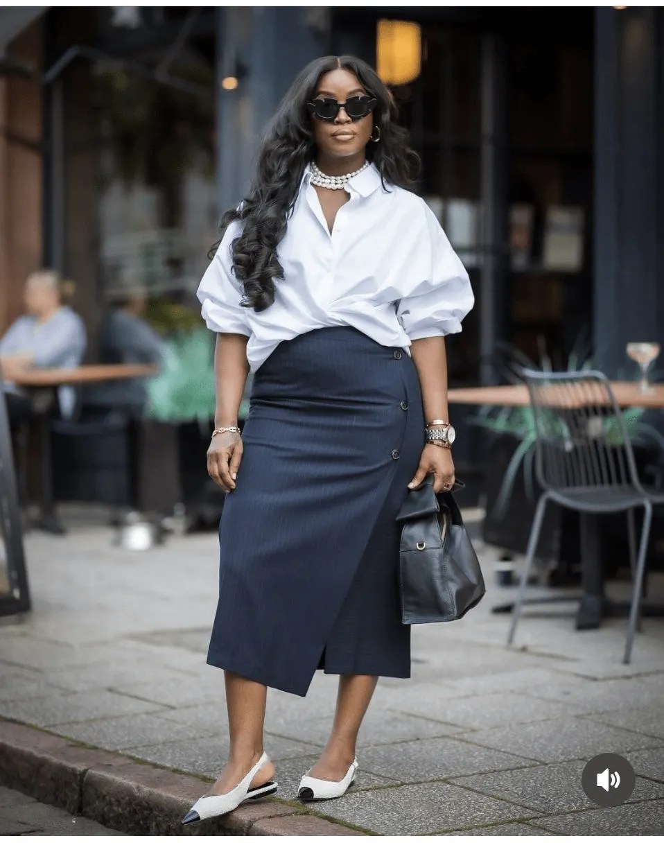 White shirt with navy structured skirt and pointed flats
