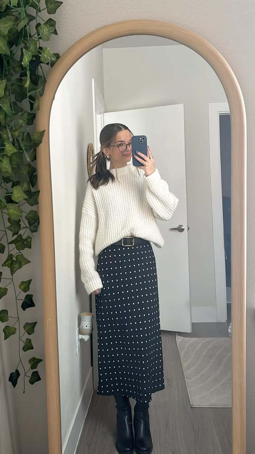 White knit sweater with black polka dot skirt and boots
